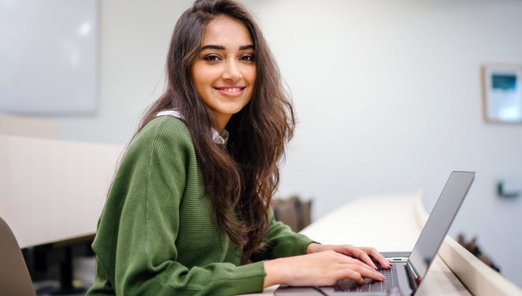 Woman smiling as she works on her laptop