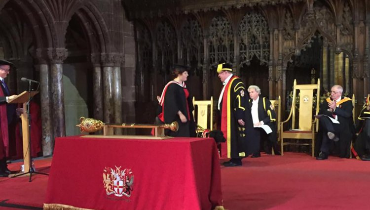 Elin and Jazzy on stage receiving degree from vice chancellor