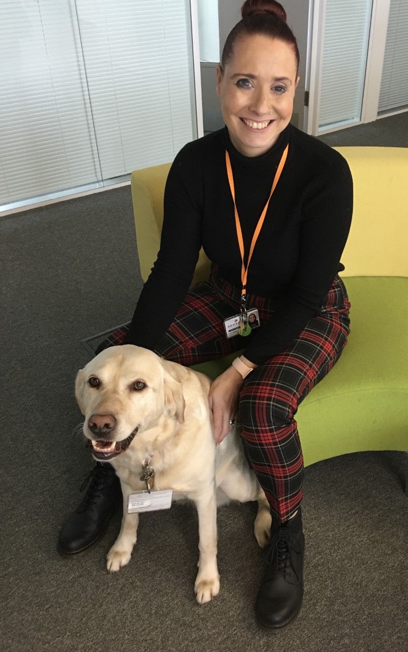 Zoe Bates sitting with her guide dog