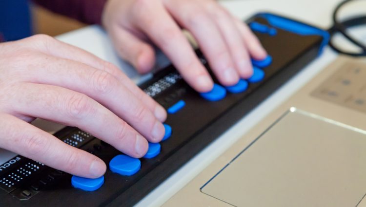 close up picture of a person using a braille keyboard