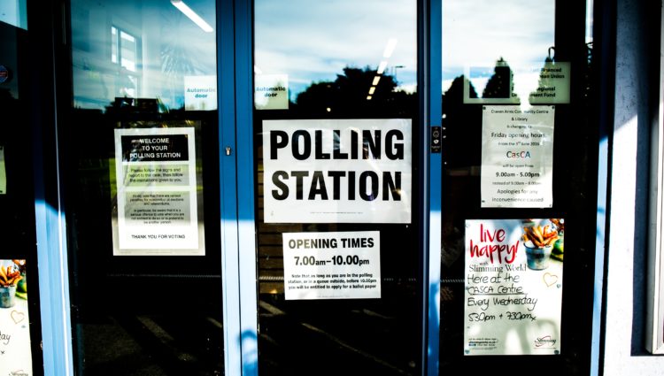 Three glass doors with a sign that says 'Polling Station'