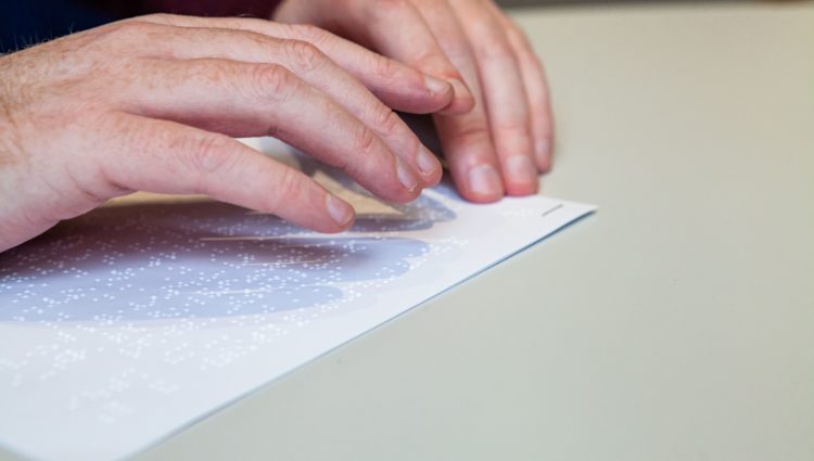 close up picture of a person reading a document in braille