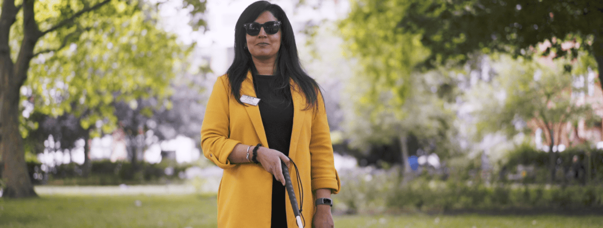 A picture of Renu walking around a park holding her cane