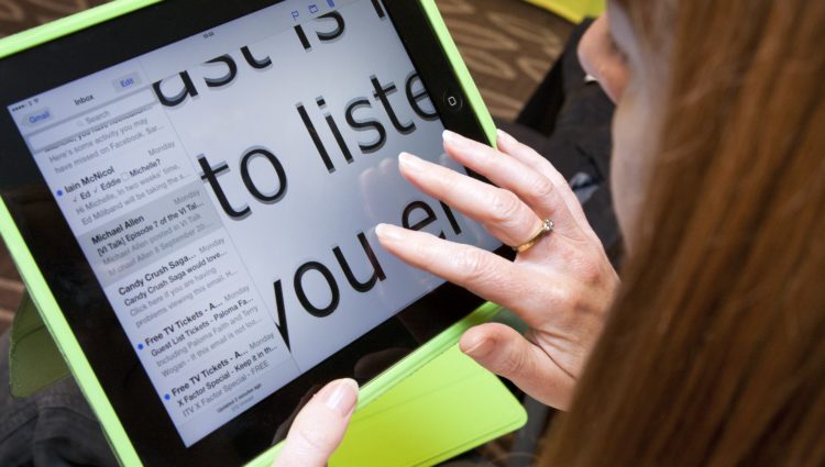 A close-up image of a woman using an ipad
