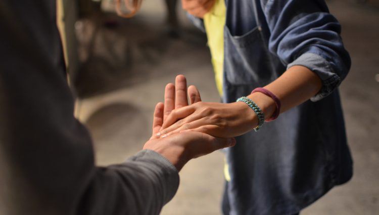 Two people touching hands from distance